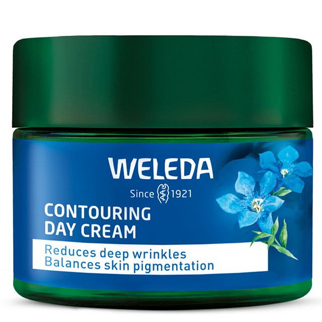 Weleda Contouring Day Cream is in a glass jar with blue label with blue flowers and a green lid on a white background
