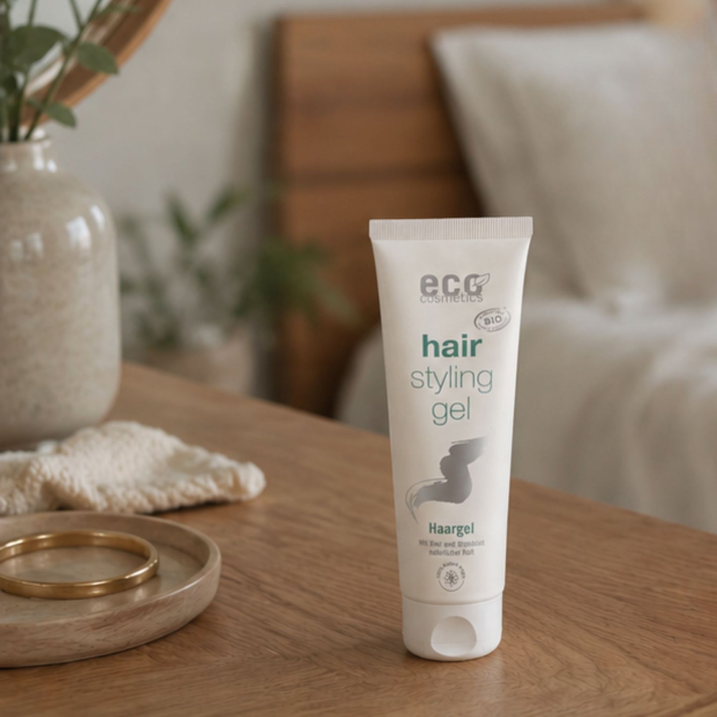 Tube of eco cosmetics hair styling gel in a bedroom background on a desk