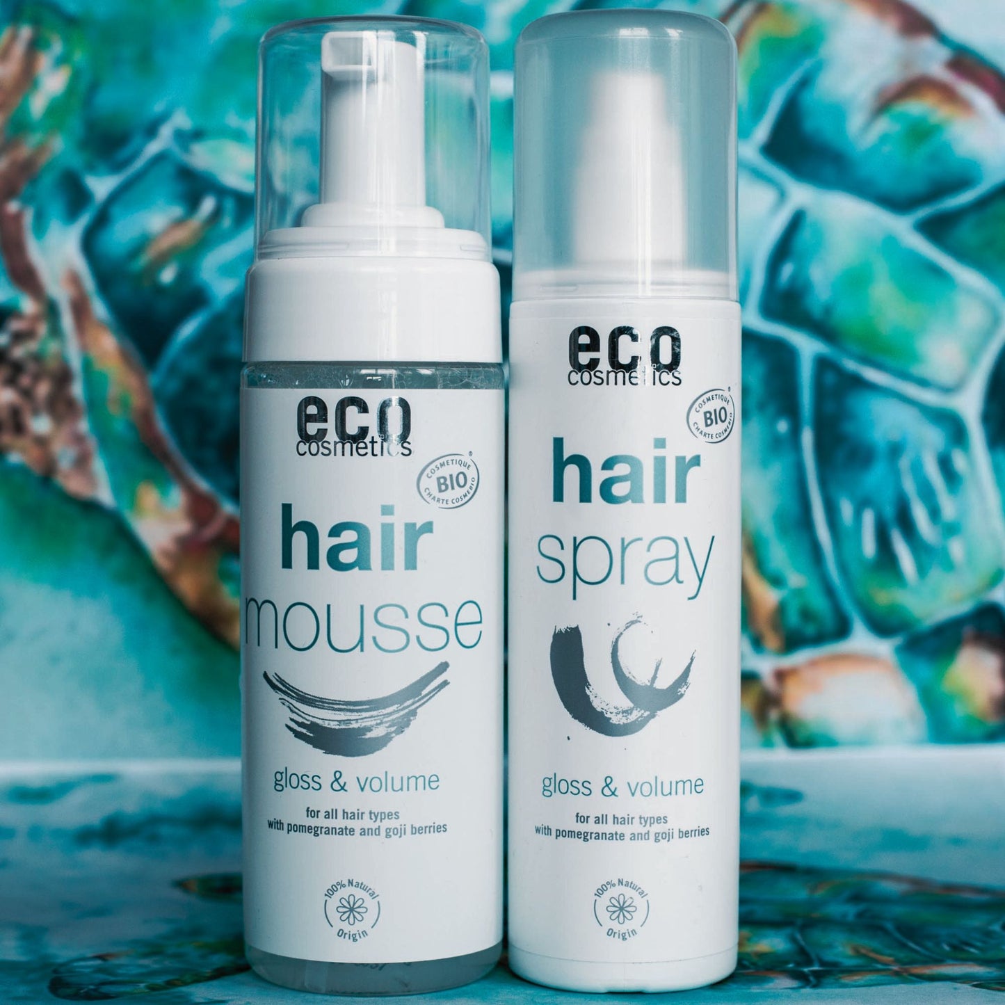 Two eco-friendly hair care products, hair mousse and hair spray, on a colorful background.