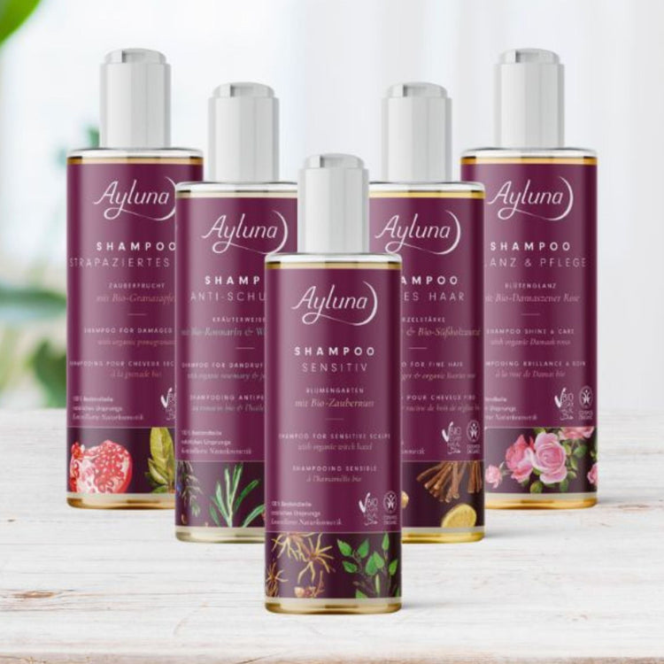 Ayluna organic hair care collection featuring plant-based shampoos for sensitive scalp, fine hair, and damaged hair. Vegan and halal certified natural cosmetics in purple bottles with botanical designs.