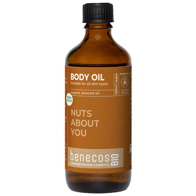 Benecos Bio Body Oil with organic almond oil  for all skin types in a brown glass bottle with a light brown label and a screw top lid.