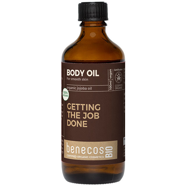 Benecos Body Oil with Organic Jojoba Oil for smooth skin in a brown glass bottle with a brown label and a screw top lid.