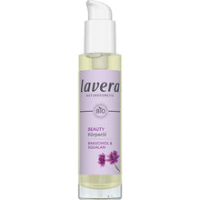 Lavera Beauty Body Oil is in a glass bottle with a purple label and a white spray cap on a white background