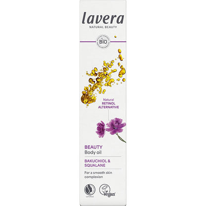 Lavera Beauty Body Oil is in a white box with gold oil drops and a purple flower on a white background