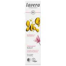 Lavera Indulgent Body Oil is in a white box with gold oil drops and magnolia flower on a white background