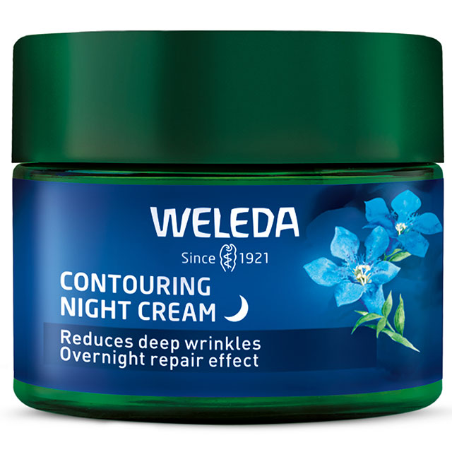 Weleda contouring night cream is in a glass jar with a blue label with blue flowers and a green lid on a white background