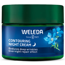 Weleda contouring night cream is in a glass jar with a blue label with blue flowers and a green lid on a white background