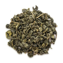 Pile of green tea leaves on a white background