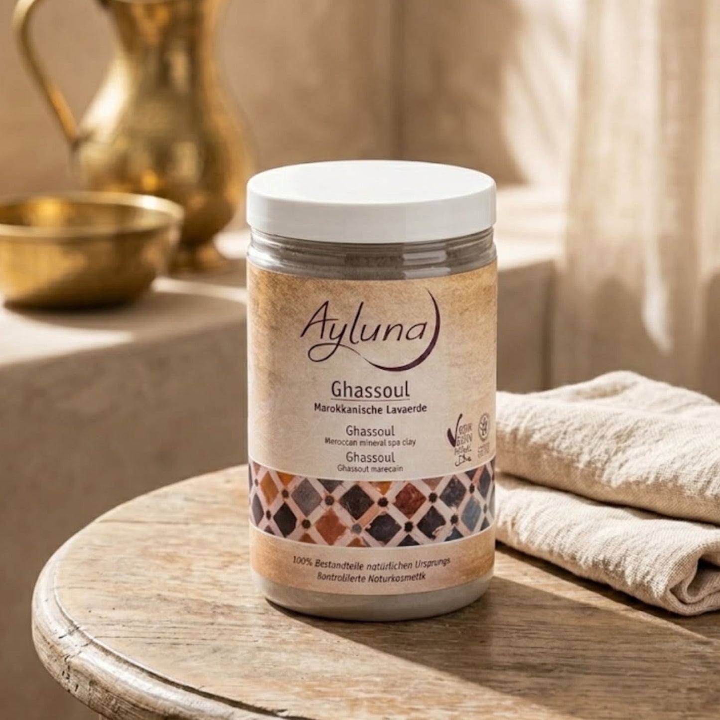 Ayluna Ghassoul Moroccan Minera Spa Clay in a jar in a bathroom.
