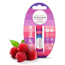 Ben & Anna Raspberry lip balm in a pink and purple blister card package, shown with fresh raspberries and green leaves on a white background.