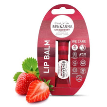 Ben & Anna Strawberry Lip Balm in a red tube, presented in its original red cardboard packaging with a hanger tab, accompanied by fresh strawberry slices and leaves on a white background.