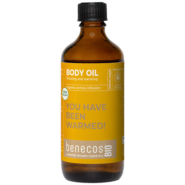 Benecos Bio Body Oil with and Organic Arnica Infusion in a brown glass bottle with a mustard coloured label with a screw top lid.