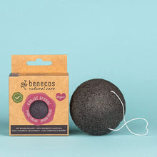 A Benecos natural care Konjac Spongie (bamboo charcoal sponge) shown next to its brown cardboard packaging box on a solid light blue background.