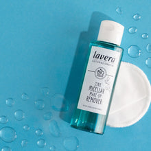 Lavera 2 in 1 Micellar Make-Up Remover plastic bottle with a flip top lid and cotton pad on a blue background