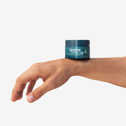 Lavera Natural Beauty Barrier Balance Night Cream jar on a arm with plain white background.