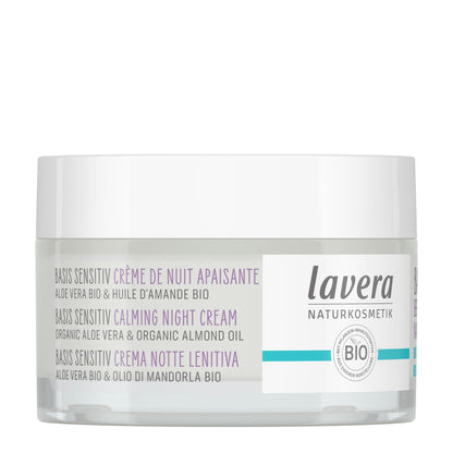A jar of Lavera 'Basis Sensitive Calming Night Cream' on a clean white background. The product is in a clear jar showing the white cream inside, with a white lid and a white label featuring purple and teal text and accents.
