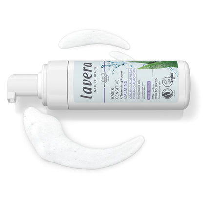 Lavera Basis Sensitive Cleansing Foam bottle on side with cleansing foam coming out on a white background