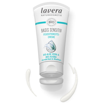 A white squeeze tube of Lavera Basis Sensitive Moisturising Creme with teal accents, shown on a white background with a dollop of the cream in front of it.