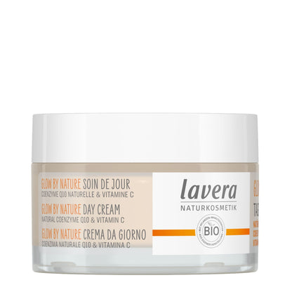 A jar of Lavera Glow by Nature Day Cream on a clean white background. The product is in a clear glass jar showing a beige cream inside, with a white lid and a white label featuring orange and black text.