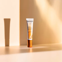 Lavera Glow by Nature Illuminating Eye Cream in a white squeeze tube with an orange cap with beige background.