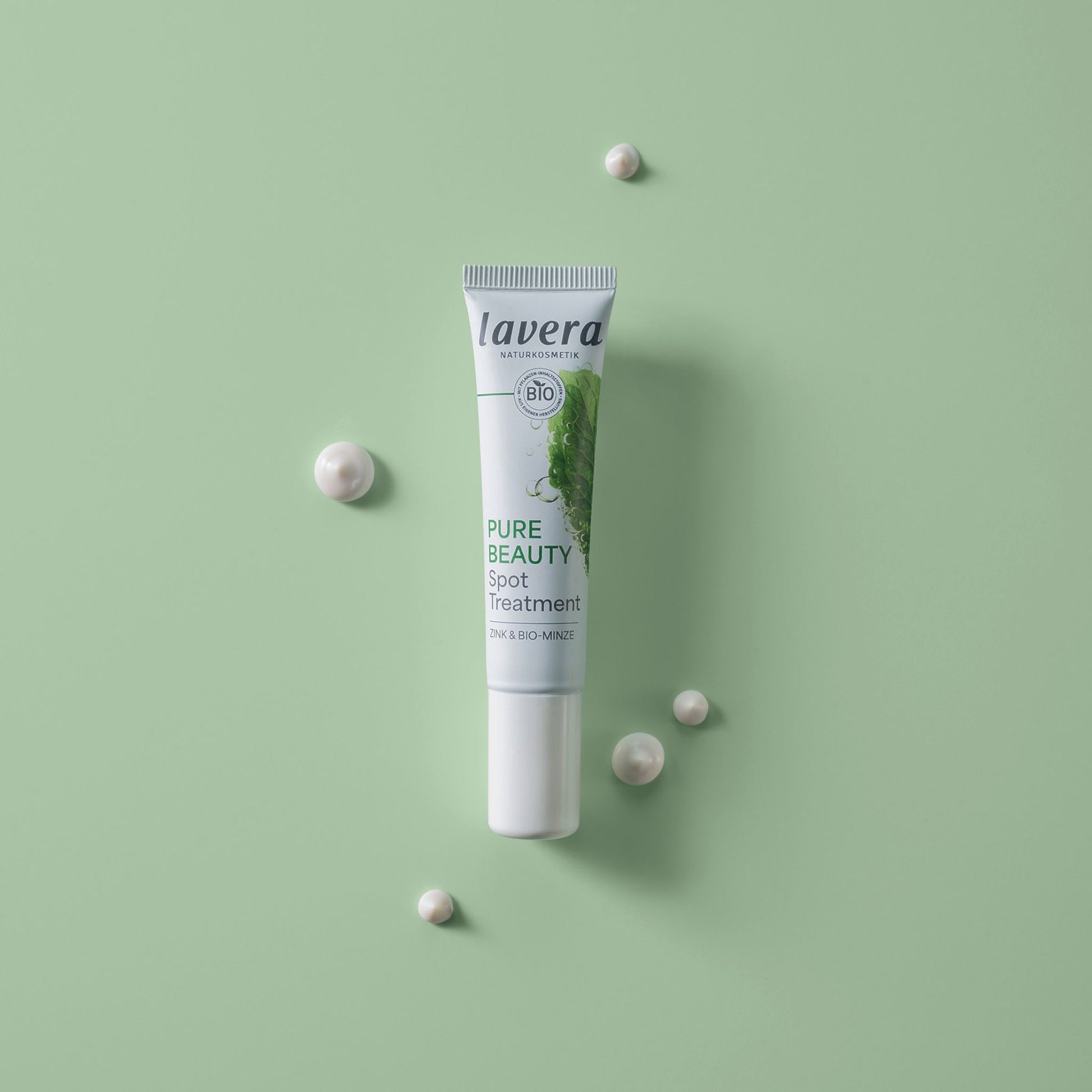 A tube of lavera Pure Beauty Spot Treatment is displayed vertically on a light green background.
