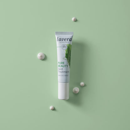 A tube of lavera Pure Beauty Spot Treatment is displayed vertically on a light green background.