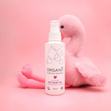 Organii Organic Dry Baby Oil for babies and children, a pump bottle with soft toy on pink background