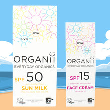 Box holding Organii SPF50 Sun Milk and a Box holding SPF15 Face Cream on a beach background